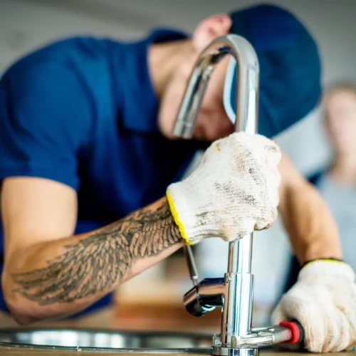 Plumber fixing kitchen sink
